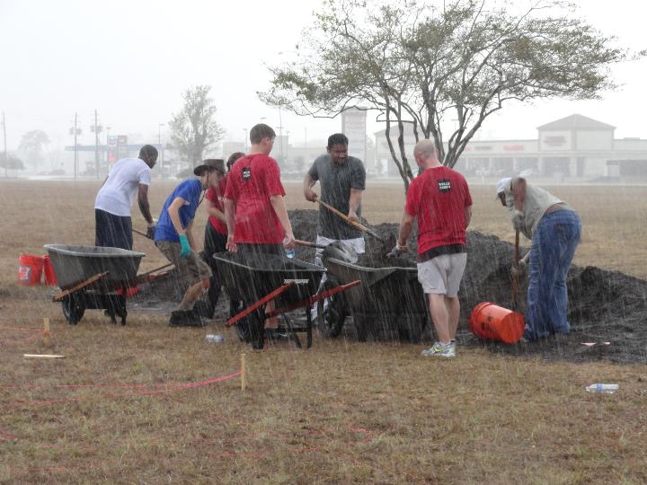 Volunteers working through the rainstorm on build day, 2011